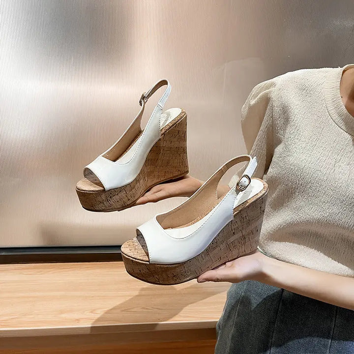 A pair of open-toe platform heels with a textured upper in white