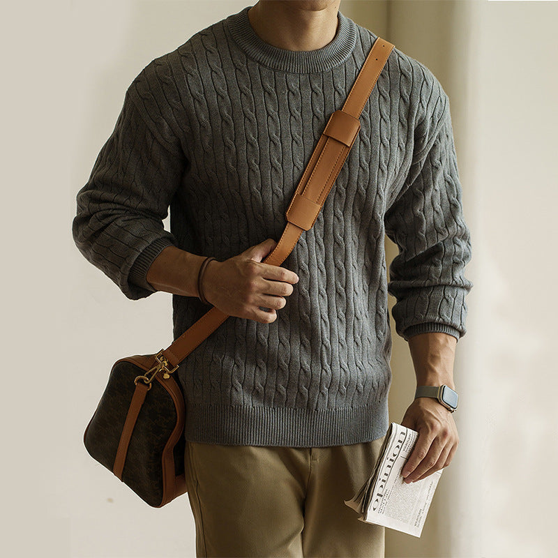 Men's grey cable-knit crew neck sweater styled for fall and winter. Chunky knit pullover ideal for cozy and casual outfits.