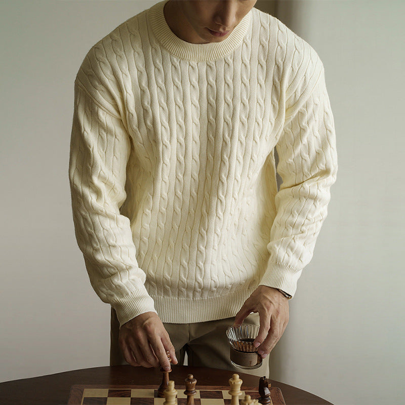 Men's cream cable-knit crew neck sweater styled for fall and winter. Chunky knit pullover ideal for cozy and casual outfits.