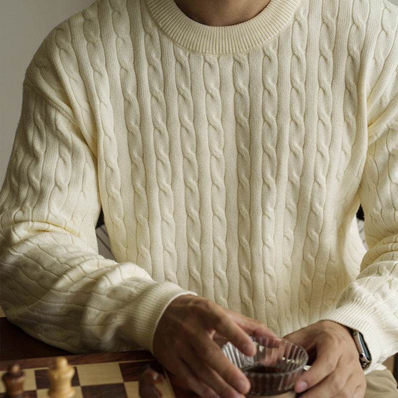 Men's cream cable-knit crew neck sweater styled for fall and winter. Chunky knit pullover ideal for cozy and casual outfits.