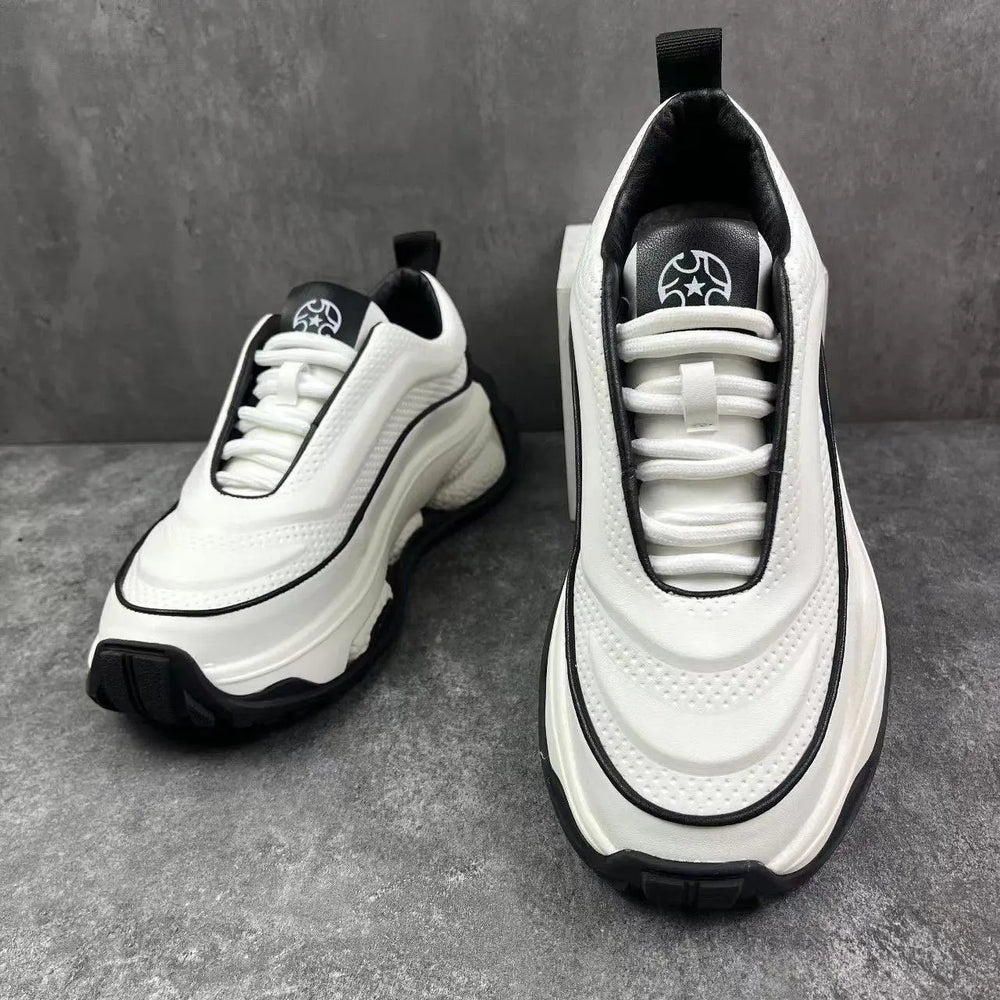 A pair of men's sneakers with a lace-up closure, featuring a white color with black accents and a thick sole.