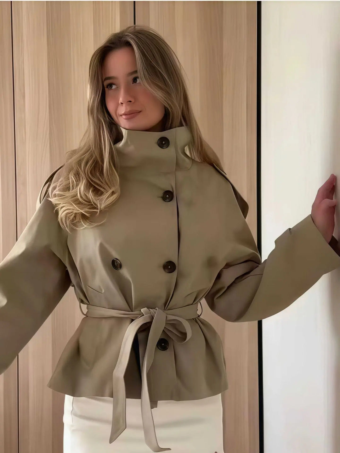 Beige double-breasted short trench coat with belted waist – elegant women’s jacket for spring and autumn.