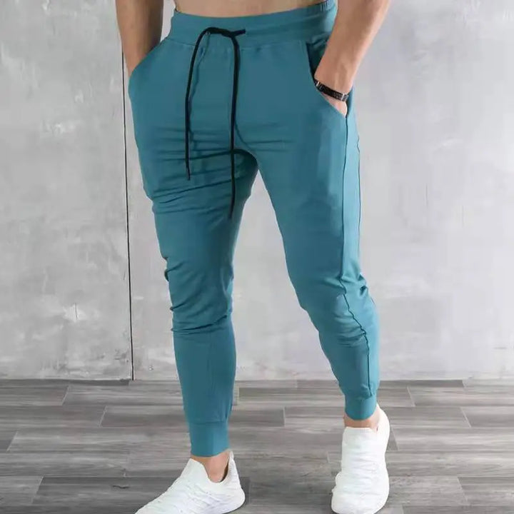 Men’s teal blue jogger pants with drawstring waist and zip pockets – athletic tapered fit for casual streetwear