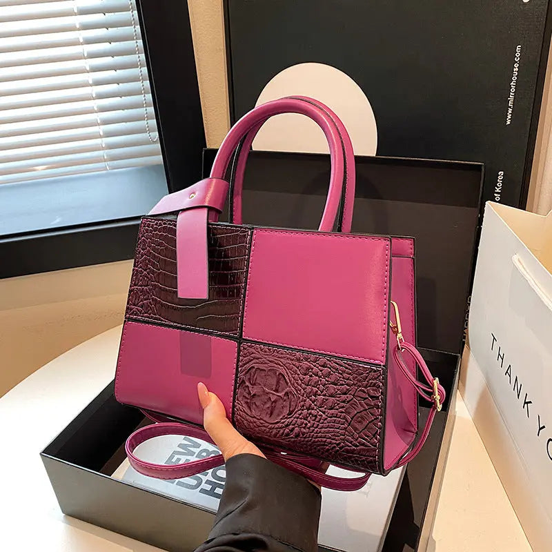 Trendy pink patchwork handbag for women featuring croc-embossed leather texture and detachable shoulder strap.