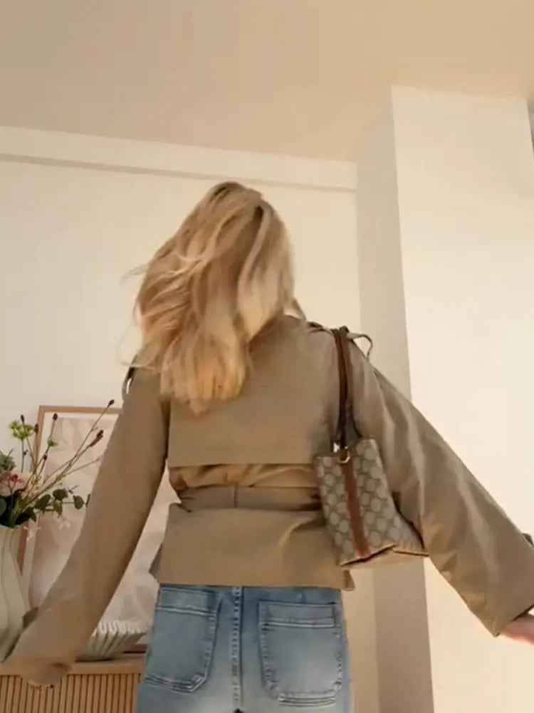 Beige double-breasted short trench coat with belted waist – elegant women’s jacket for spring and autumn.