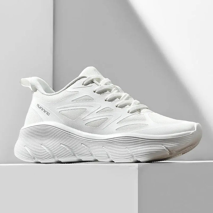 A pair of white ActiveGlide Sports Shoes placed on a pedestal, showcasing the sole design