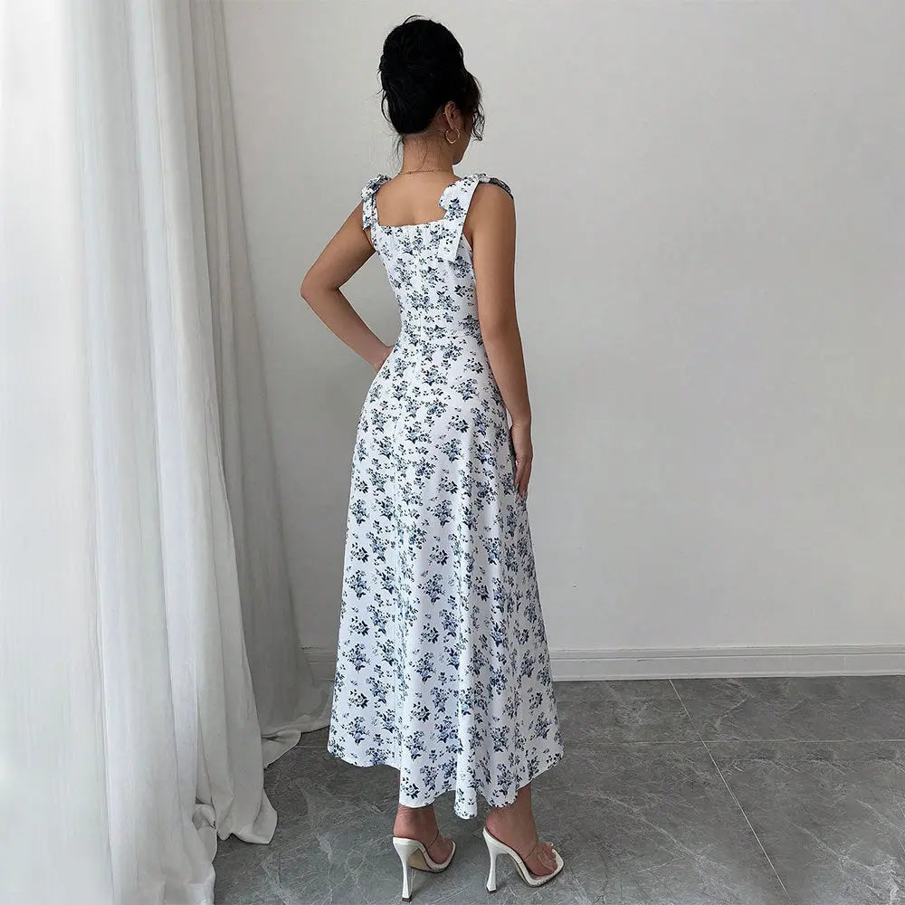 A woman modeling a floral CityChic slit dress with a square neckline and sleeveless design, featuring a side slit.