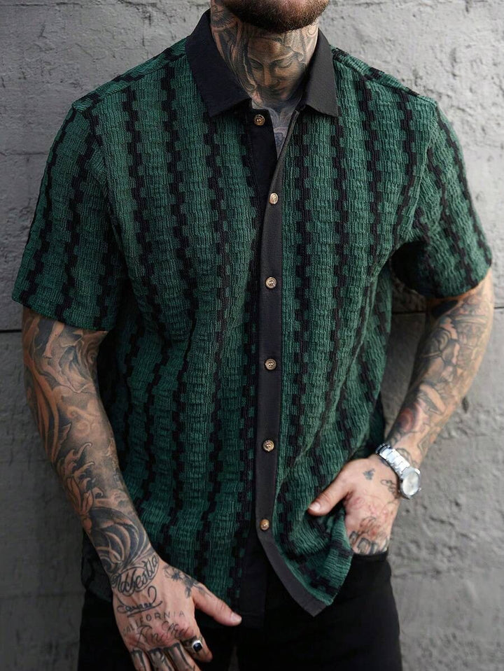 Man wearing a green patterned shirt with a black collar 