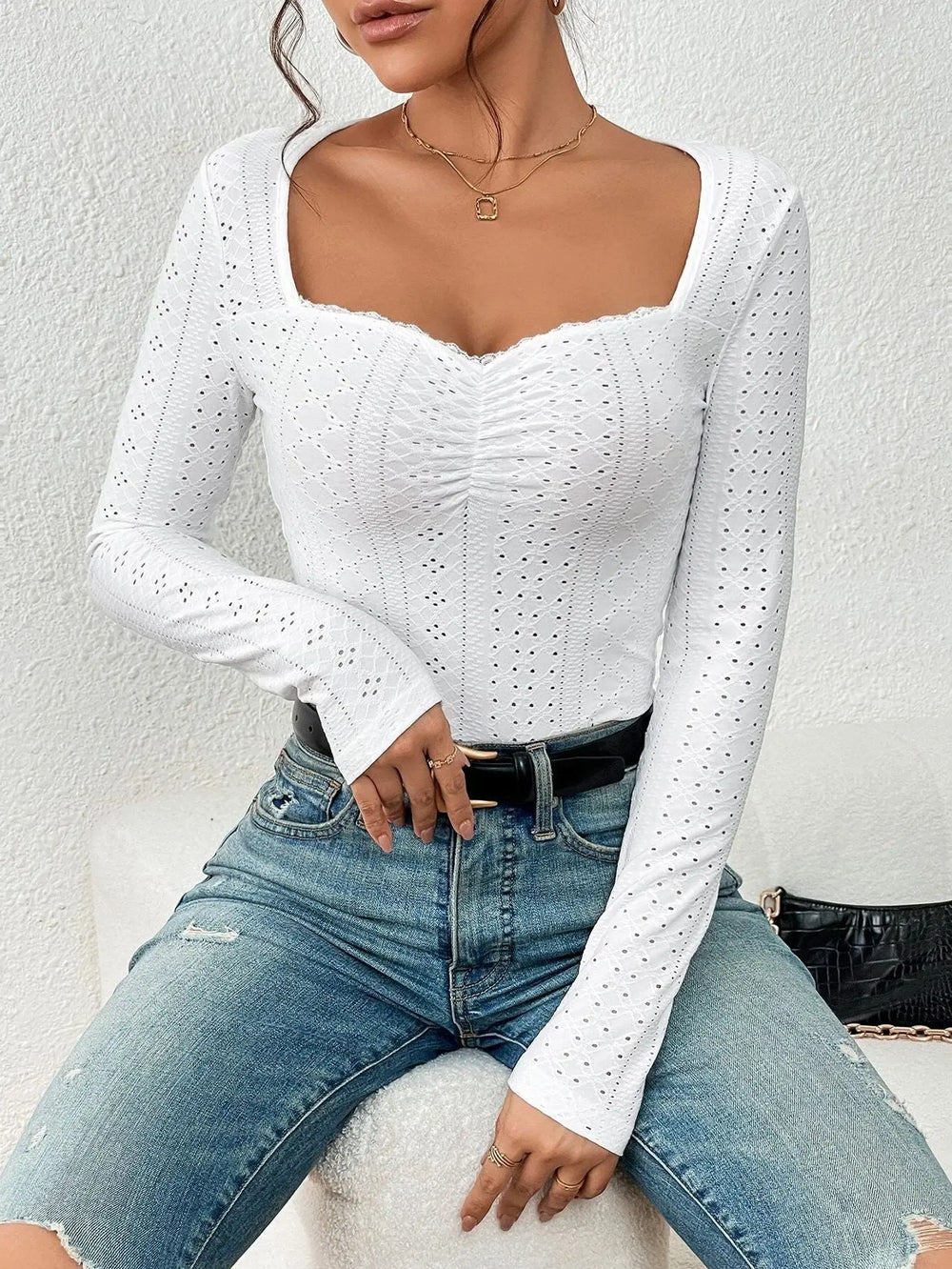 Women's white long-sleeve top with eyelet details