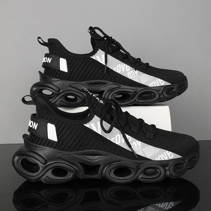 A pair of black and white sports sneakers with a breathable mesh upper and a unique sole design, displayed against a grey background.