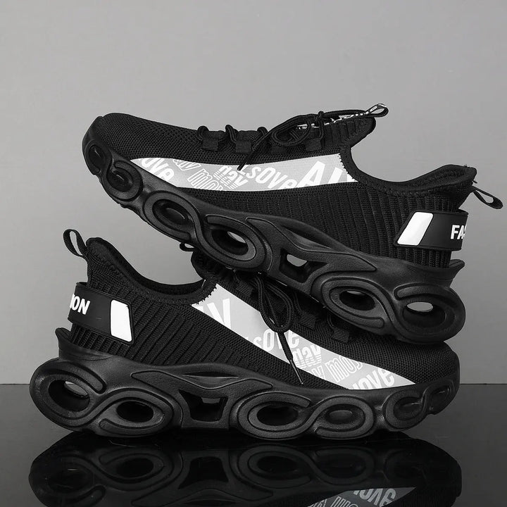 A pair of black and white sports sneakers with a breathable mesh upper and a unique sole design, displayed against a grey background.