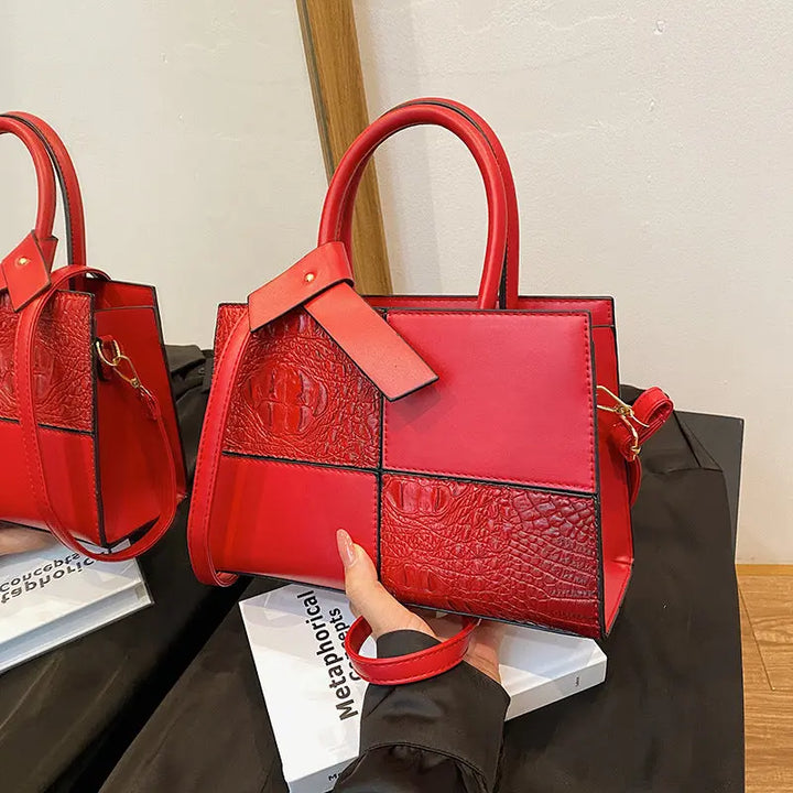 Trendy red patchwork handbag for women featuring croc-embossed leather texture and detachable shoulder strap.