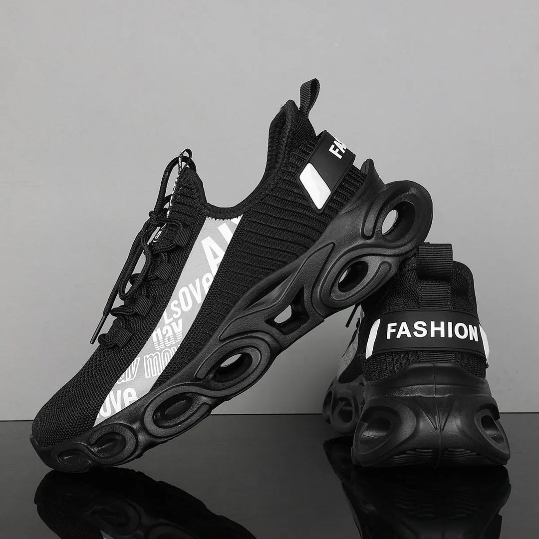 A pair of black and white sports sneakers with a breathable mesh upper and a unique sole design, displayed against a grey background.