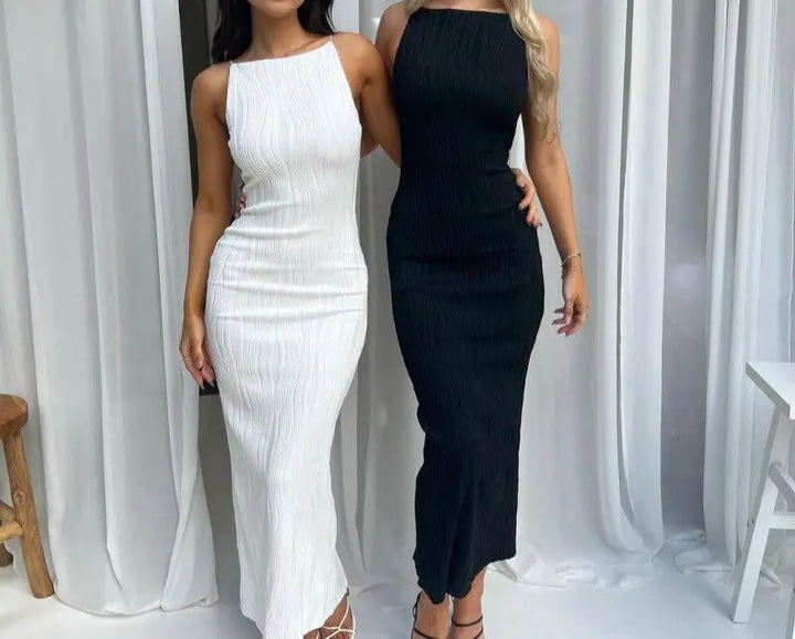 Two models wearing sleeveless maxi dresses, one in white and one in black, standing side by side.