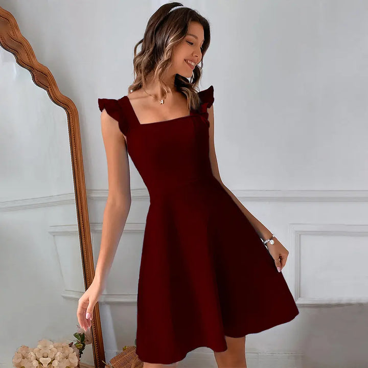 A woman wearing a red sleeveless knee-length dress with ruffled shoulder straps.