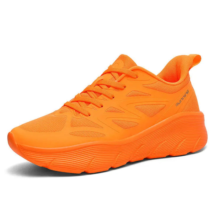 A pair of orange ActiveGlide Sports Shoes placed on a pedestal, showcasing the sole design