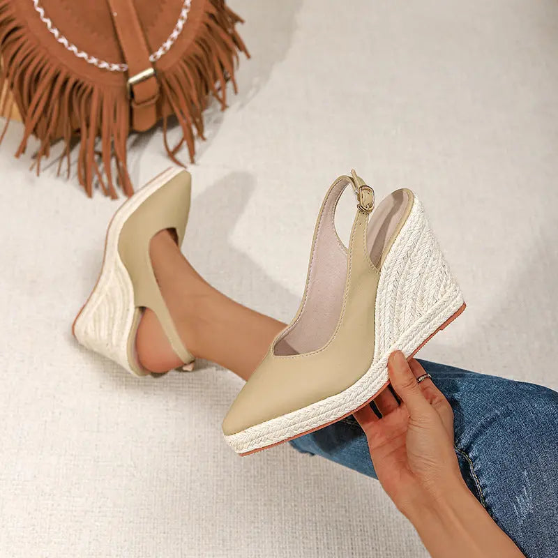 A pair of beige closed-toe high heels with buckle strap and wedge heel