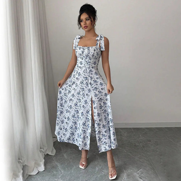 A woman modeling a floral CityChic slit dress with a square neckline and sleeveless design, featuring a side slit.