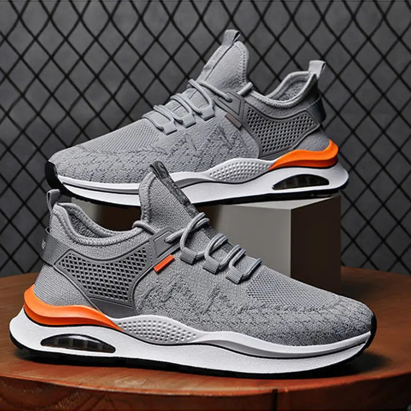 A pair of gray and white sneakers with red accents