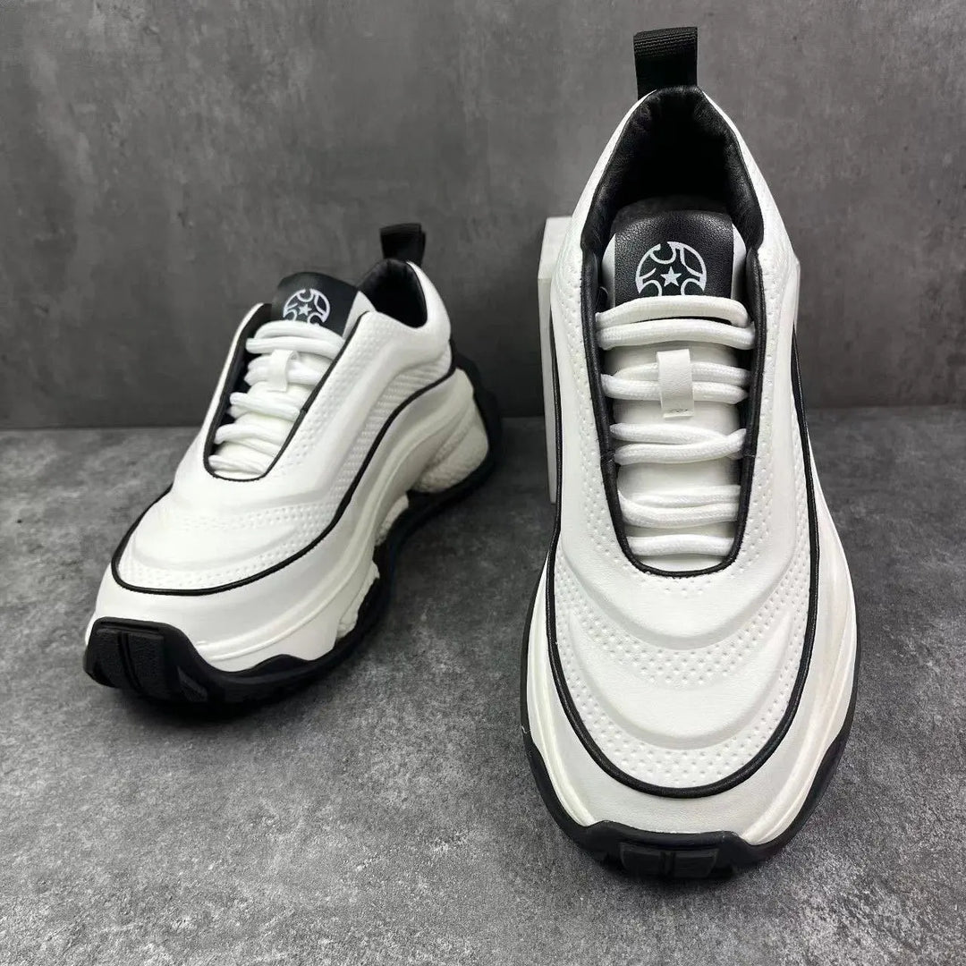 A pair of men's sneakers with a lace-up closure, featuring a white color with black accents and a thick sole.