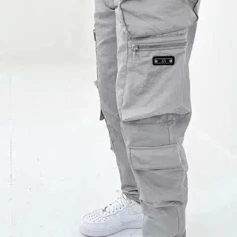 A pair of men's casual gray trousers with multiple pockets and zippers, designed for versatility and functionality.