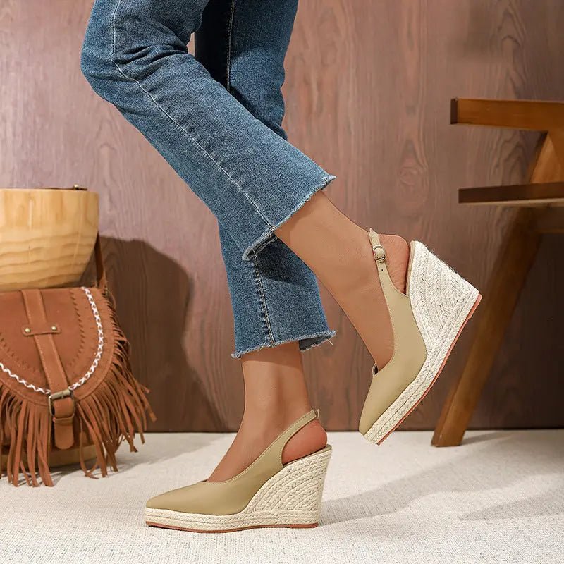 A pair of beige closed-toe high heels with buckle strap and wedge heel