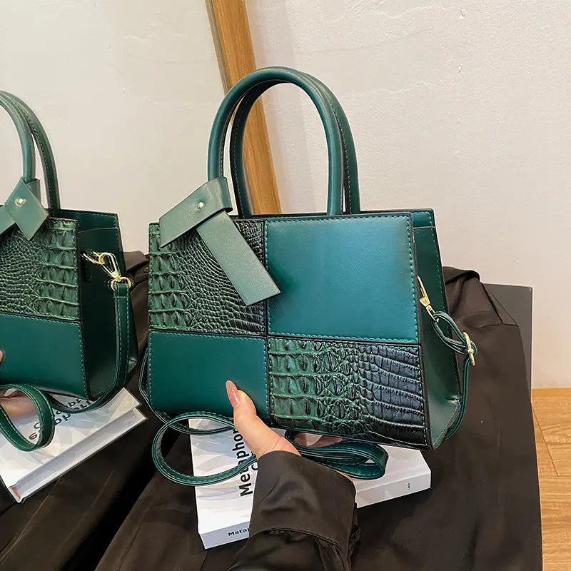 Trendy green patchwork handbag for women featuring croc-embossed leather texture and detachable shoulder strap.