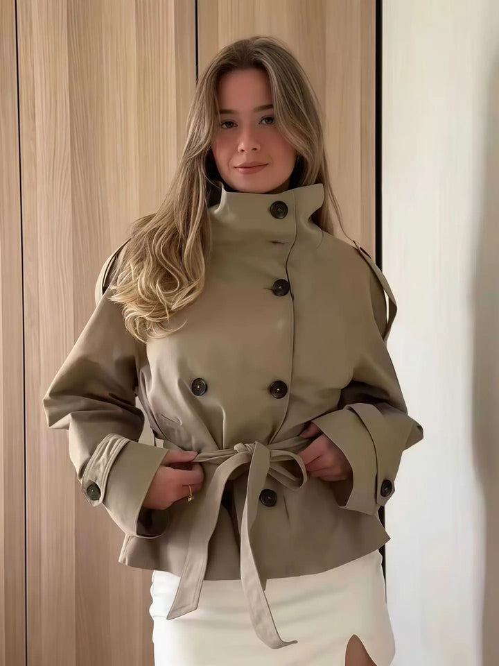 Beige double-breasted short trench coat with belted waist – elegant women’s jacket for spring and autumn.