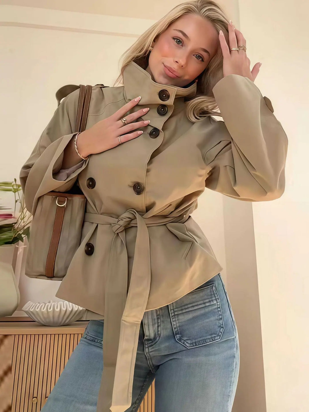 Beige double-breasted short trench coat with belted waist – elegant women’s jacket for spring and autumn.